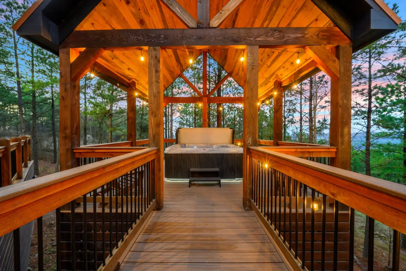 This stunning timber-framed hot tub gazebo overlooks the forest with ambient lighting and endless mountain views.