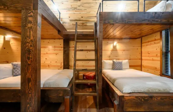 Cozy bunk room with rustic wood construction and plenty of sleeping space perfect for families or groups.