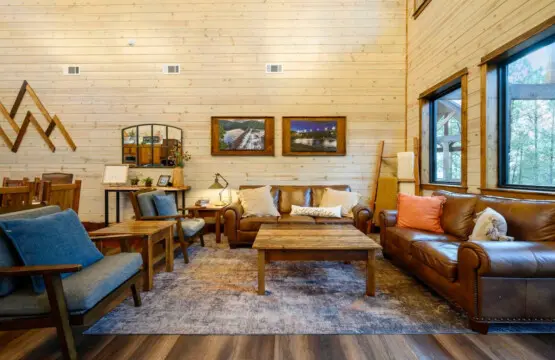 Cozy living room with leather seating, wood beams, and plenty of natural light from those huge windows.