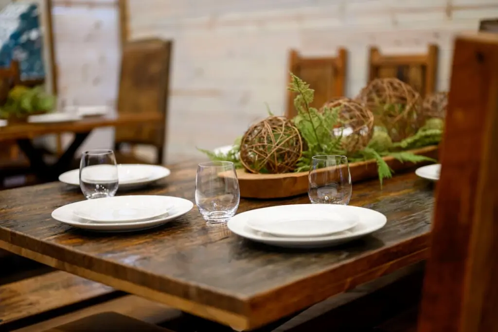 The rustic wood dining table seats guests in a warm, intimate setting with authentic charm.