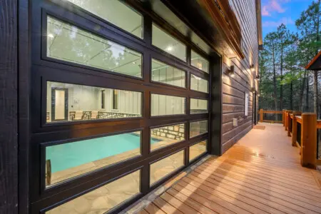 Floor-to-ceiling windows showcase an indoor pool right from your private deck overlooking the forest.
