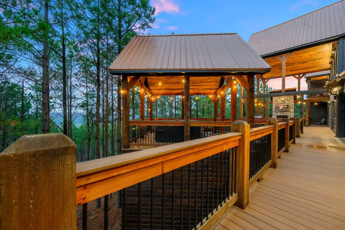 This stunning deck wraps around a gorgeous covered pavilion with mountain views and connects to the main house perfectly.