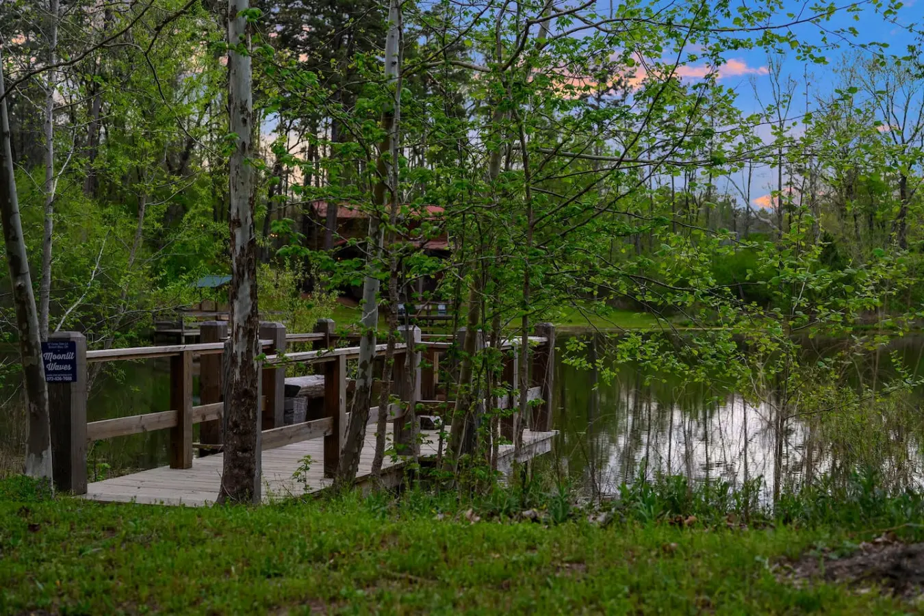 This inviting cabin deck offers peaceful views of the tranquil pond.
