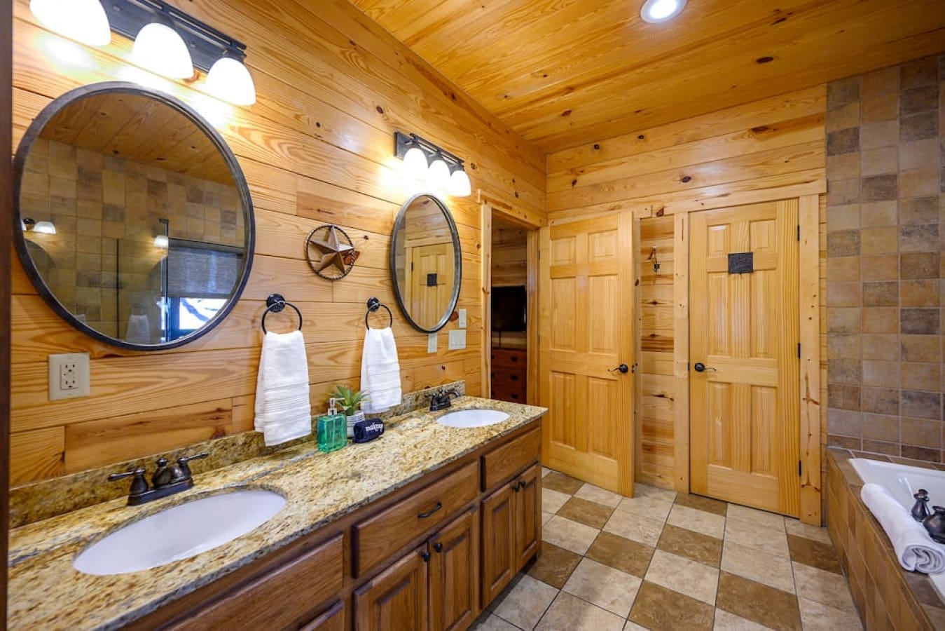 The master bathroom in our cabin features a spacious and luxurious layout, with a double vanity providing ample counter space and storage. The large mirror and warm lighting make it easy to get ready in the morning or freshen up after a long day.