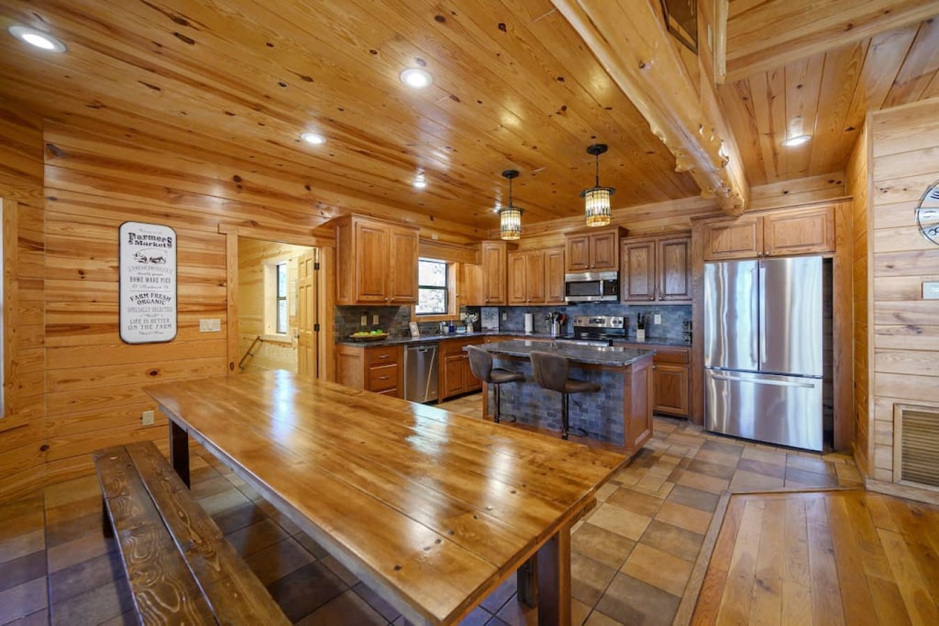 Our cabin's dining area/kitchen is a spacious and fully-equipped space, perfect for preparing and enjoying home-cooked meals. The large dining table provides plenty of seating for everyone, making it an ideal spot for gatherings with friends and family.