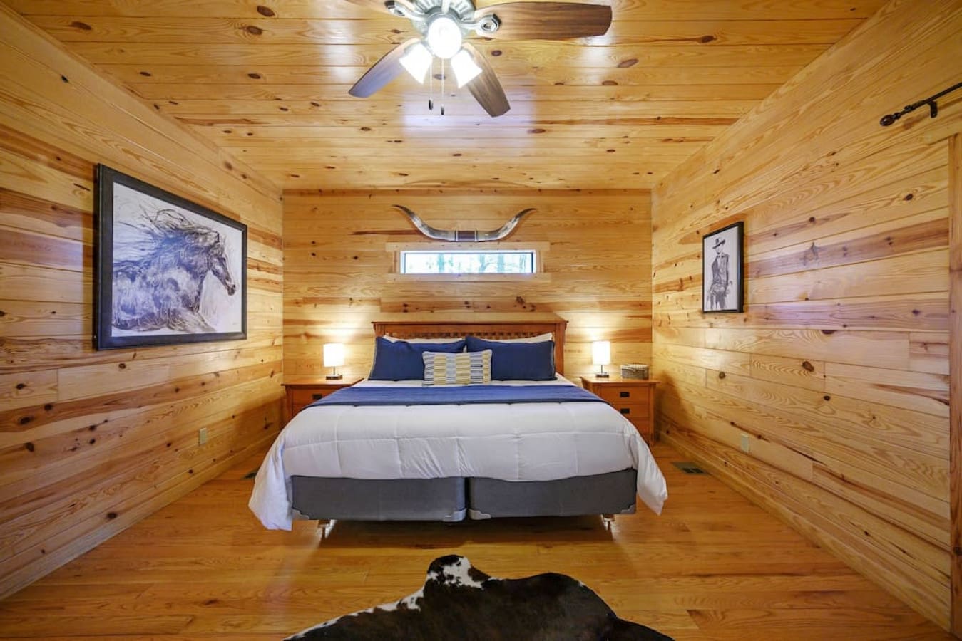 Enjoy The Eastwood decor in our master bedroom, perfectly encompassing the ambiance of the cabin. The silky cowhide rug, gorgeous painting, longhorns and Clint Eastwood inspired picture come together to create a space for you to forget about your worries.