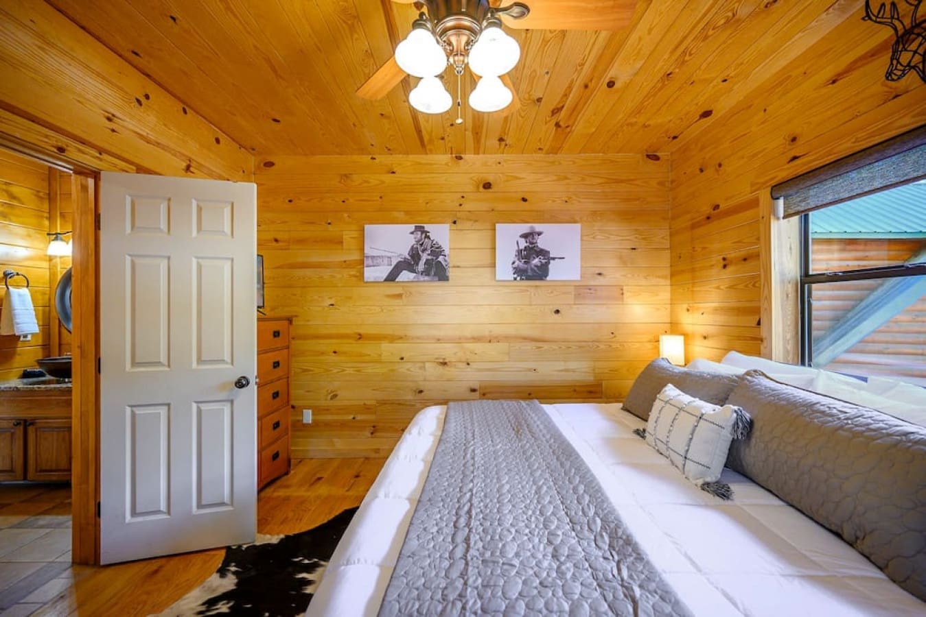 Experience the perfect bedroom with ample natural light streaming through a wide window and gentle illumination from ceiling lights.