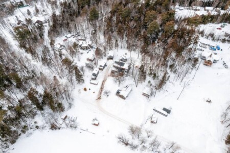 A blanket of snow drapes the cabin, painting a serene winter scene.
