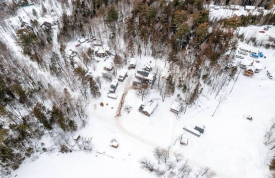 A blanket of snow drapes the cabin, painting a serene winter scene.