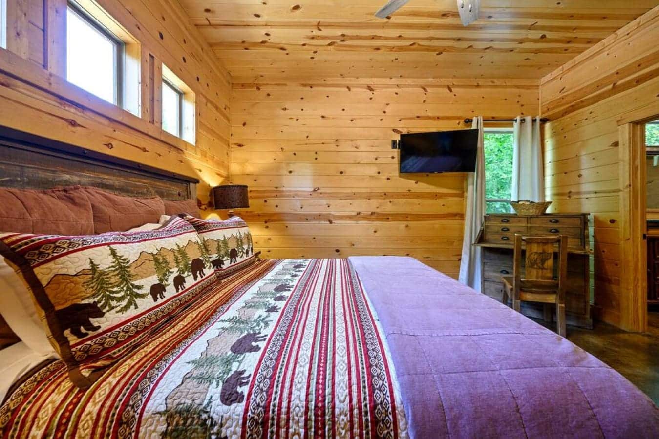 Escape to a dreamy cabin retreat, where the bedroom is a canvas of comfort, inviting you to experience the perfect blend of relaxation and rustic elegance.