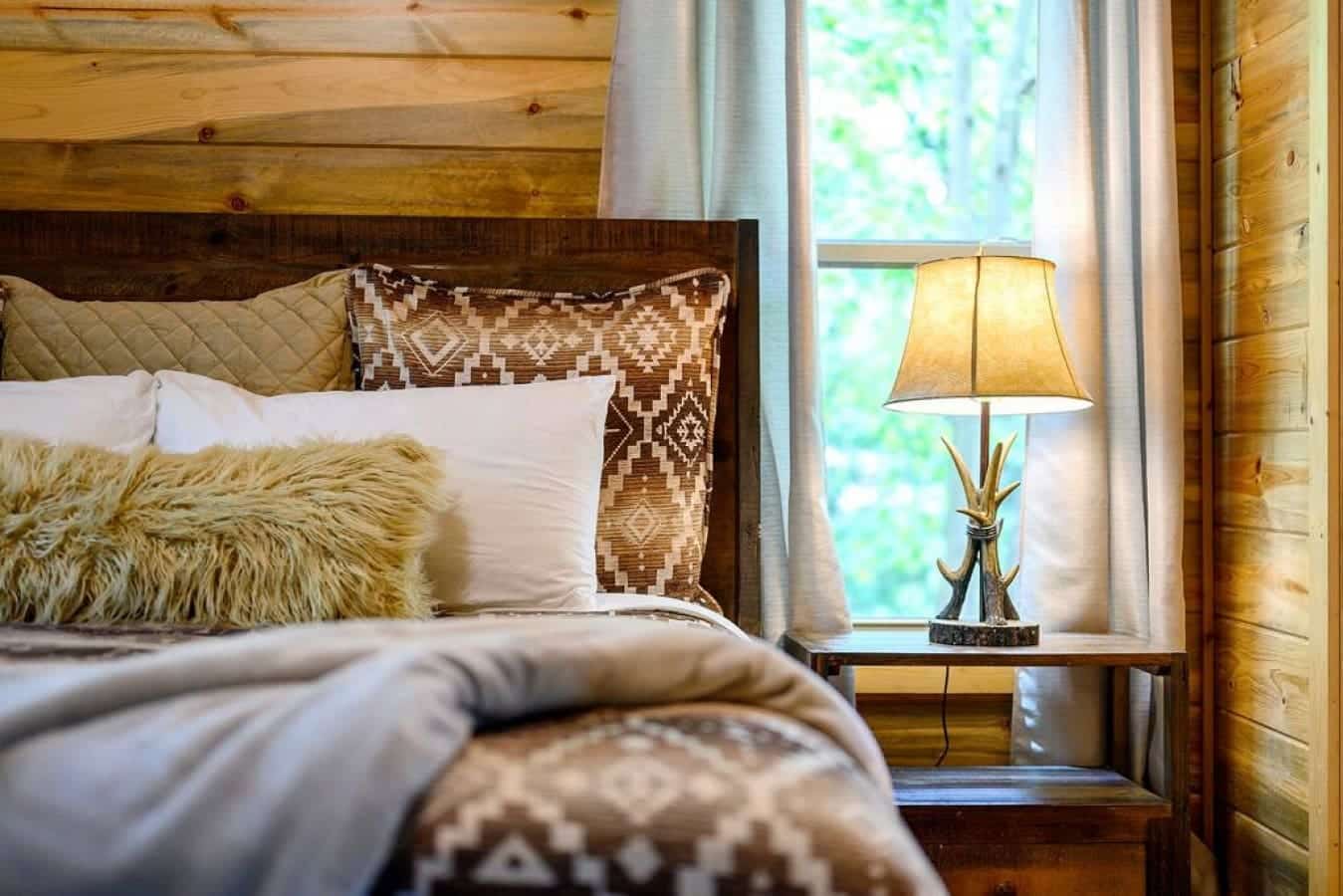 Experience the embrace of nature indoors in this cabin bedroom, where the beauty outside is mirrored in every comforting detail.