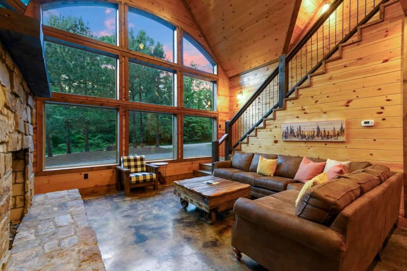 Nestled in the heart of nature, this cabin captivates with its soaring windows, framing breathtaking views and inviting the outdoors in.