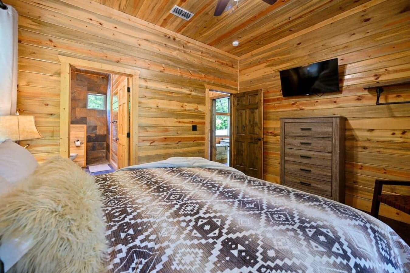 Embrace the warmth of this cabin bedroom, a retreat within a retreat, where relaxation is an art form.