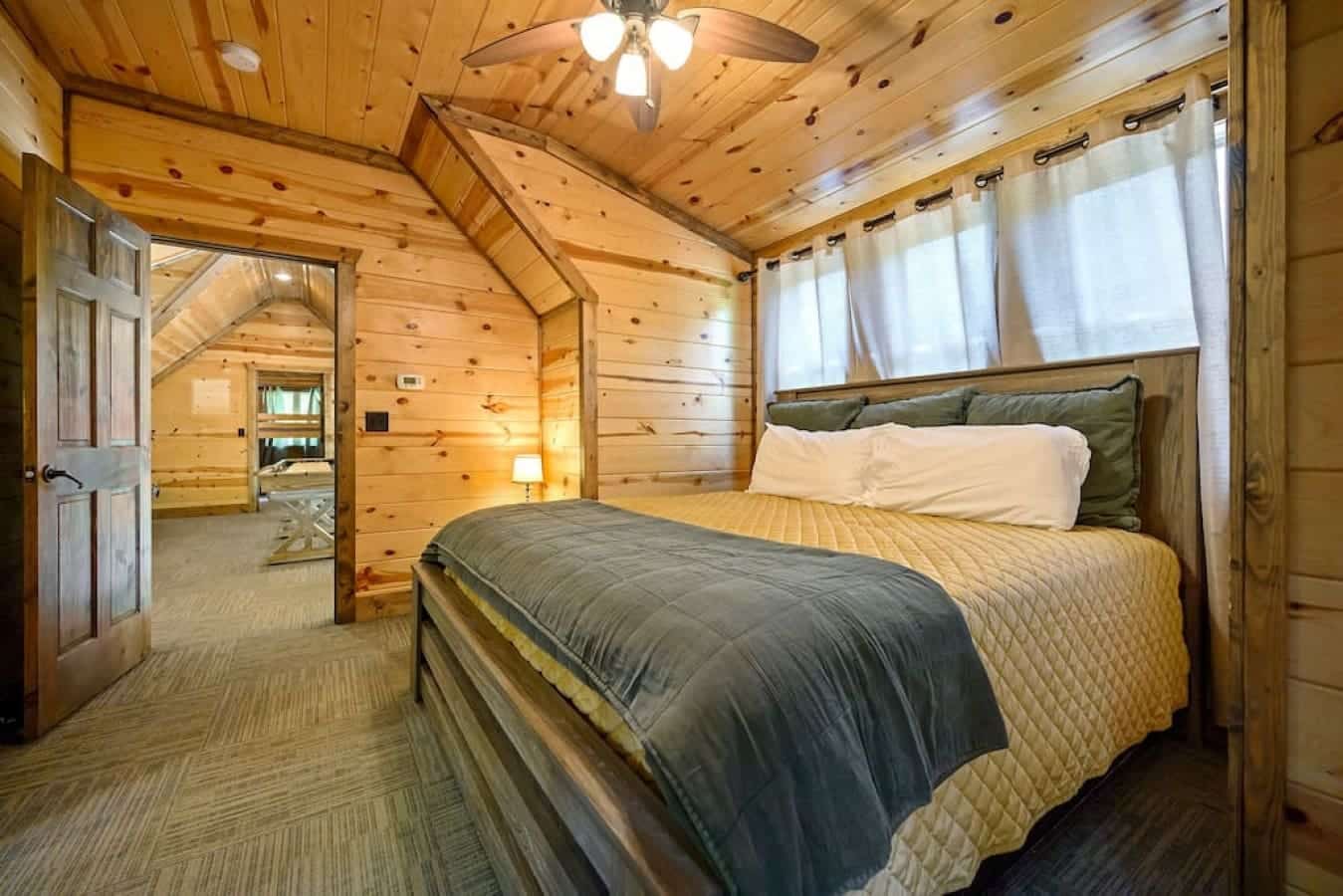 Dream under the rustic charm of this cabin bedroom, where tranquility meets cozy comfort.