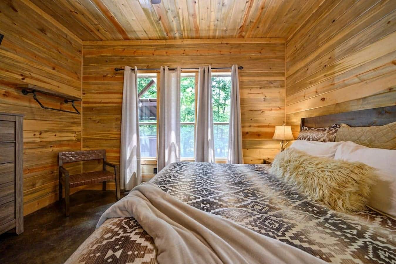 Unwind in this cabin's inviting bedroom, where each detail is a reminder of the peace found in the heart of nature.
