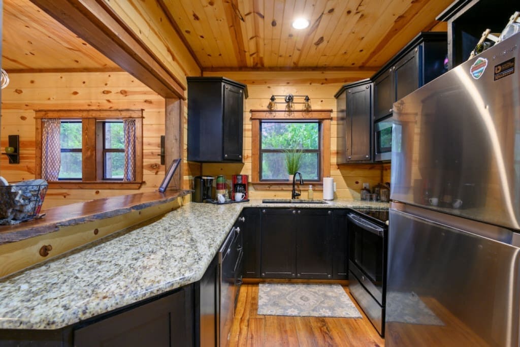Chic cabin living: where black cupboards and fridge steal the show.