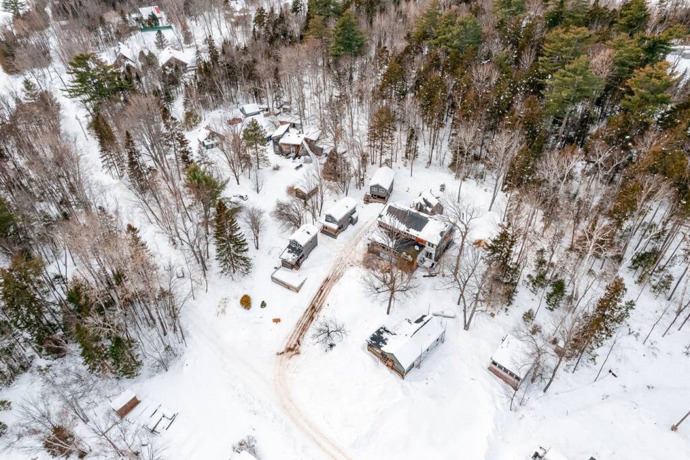 A cozy cabin nestled under a blanket of snow u2013 a winter fairy tale from above.