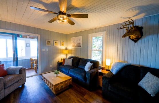 Dark sofas, warm light, and rustic charm make this the coziest post-hike retreat.
