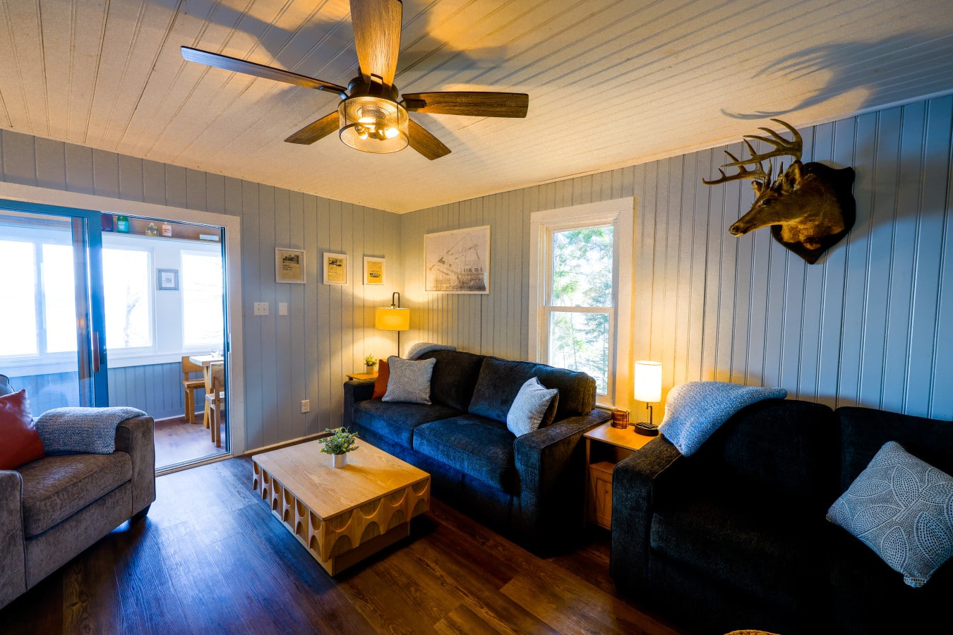 Dark sofas, warm light, and rustic charm make this the coziest post-hike retreat.