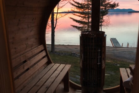 Sweat away the day while a fiery lake sunset fills your private barrel sauna window.