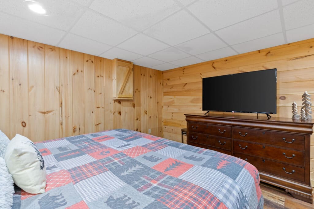 Escape to your personal haven: our bedroom oasis features a flat screen, natural wooden walls, and pristine white ceilings for a calming atmosphere.