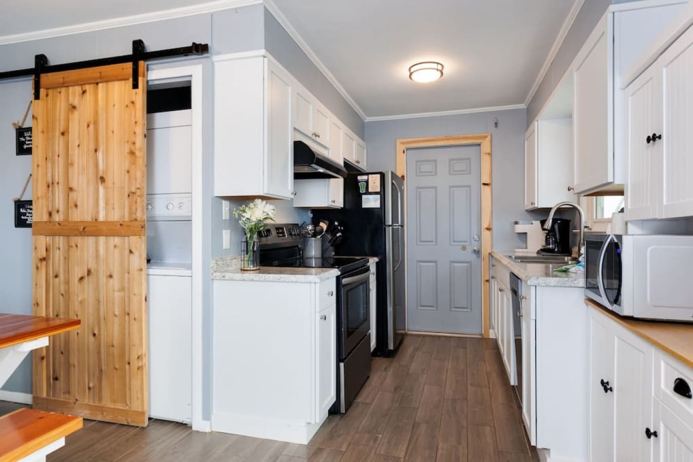 This sleek kitchen has serious style with that sliding barn door doing the heavy lifting between spaces.