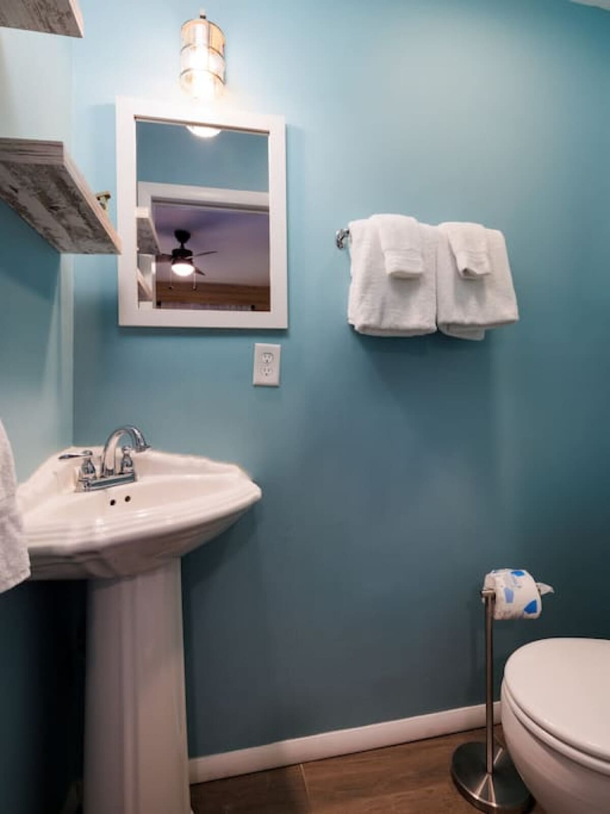 This cheerful blue bathroom with its vintage pedestal sink is basically a little spa moment every time you brush your teeth.