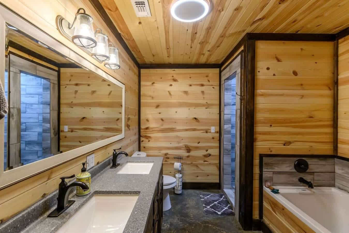 The ensuite bathroom includes dual sinks, a spacious mirror, and a bathtub for your convenience.