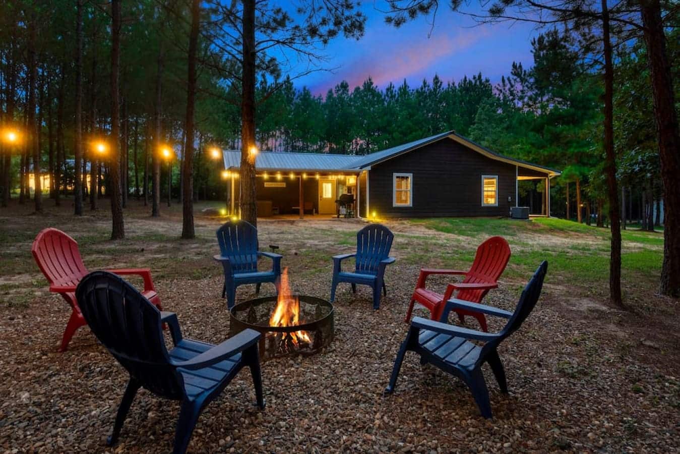 Experience the warmth of Makin Time's inviting fire pit, adorned with charming string lights and surrounded by comfortable chairs for a cozy and enchanting ambiance.