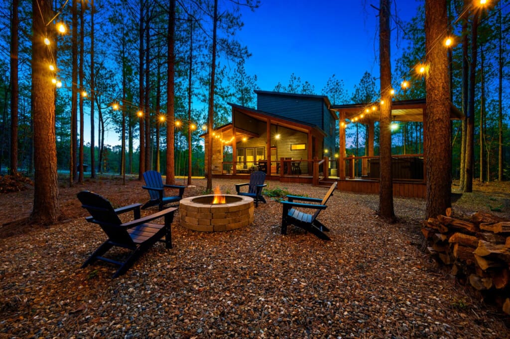 Unwind under the starry sky at Unplugged's inviting fire pit, encircled by comfortable chairs and adorned with enchanting string lights.