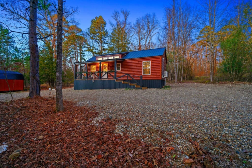 Step into serenity with this rustic cabin retreat featuring a charming balcony. Let the rhythmic rustling of leaves and the distant calls of wildlife be your soundtrack, creating the perfect harmony for a peaceful getaway.