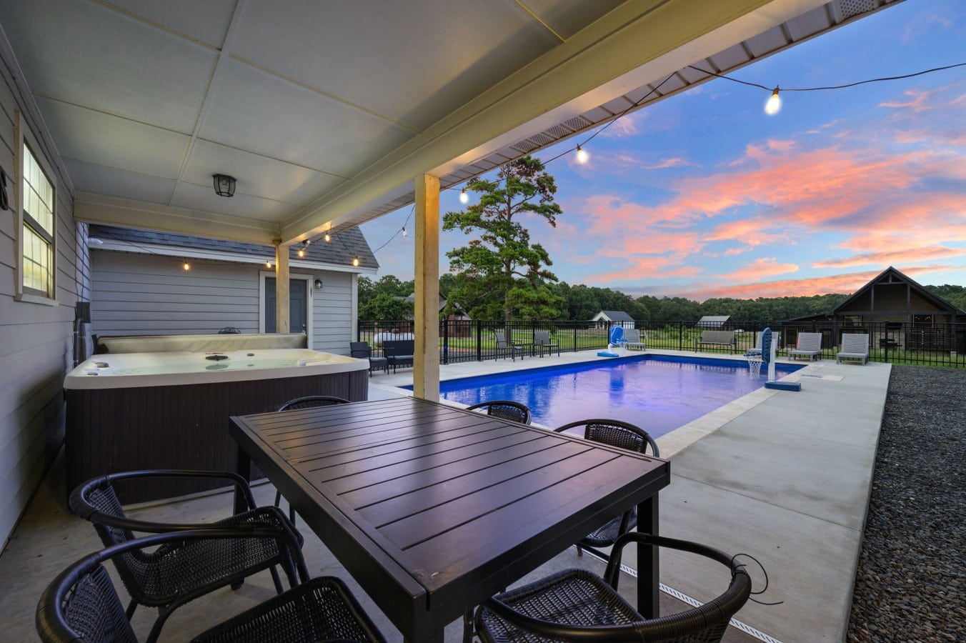 Outdoor dining table under the covered patio beside the hot tub.