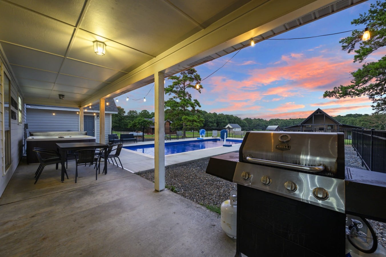 Covered patio with grill, dining space, hot tub, and pool views.