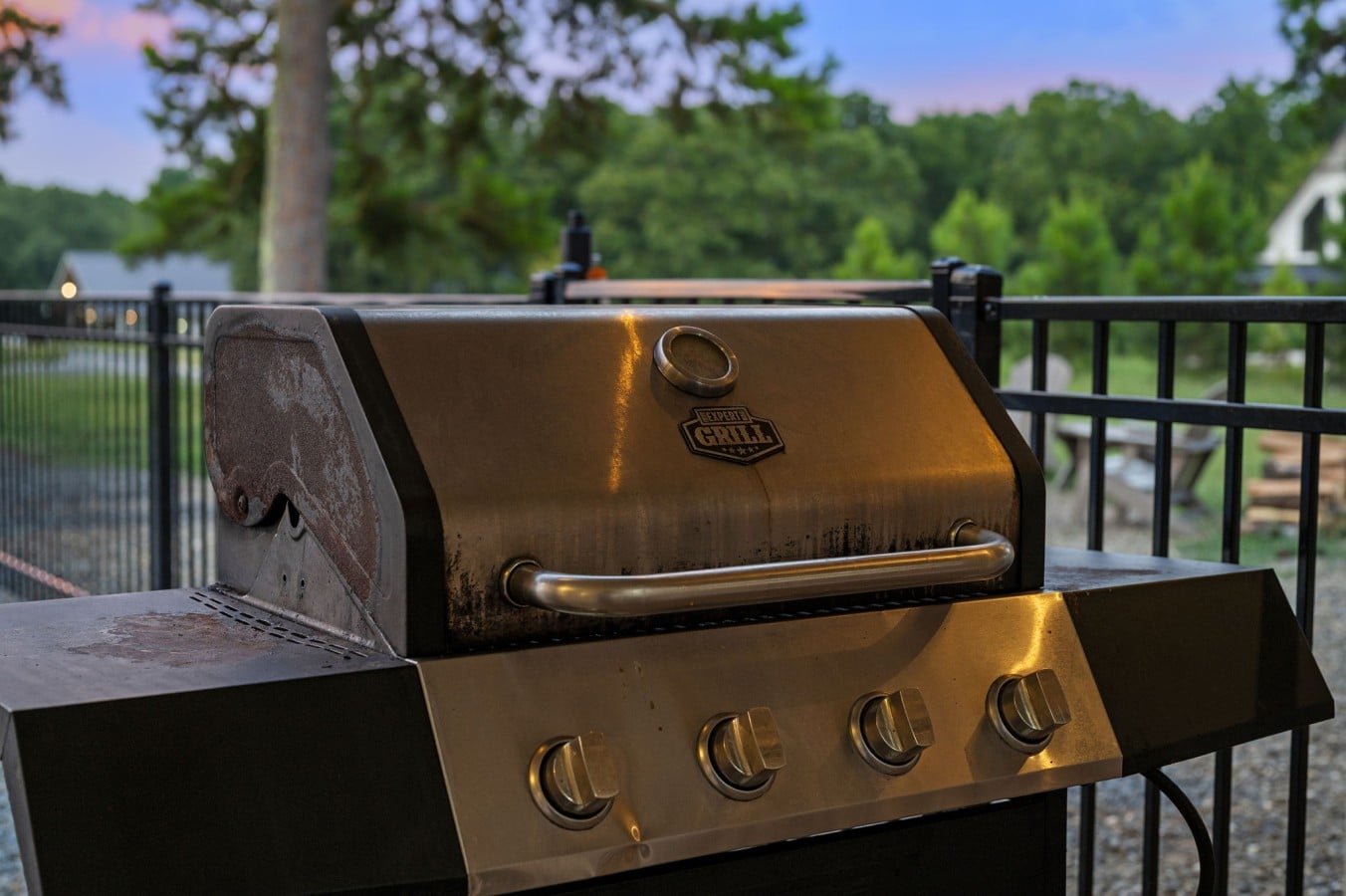 Gas grill positioned by the pool for easy outdoor meals.