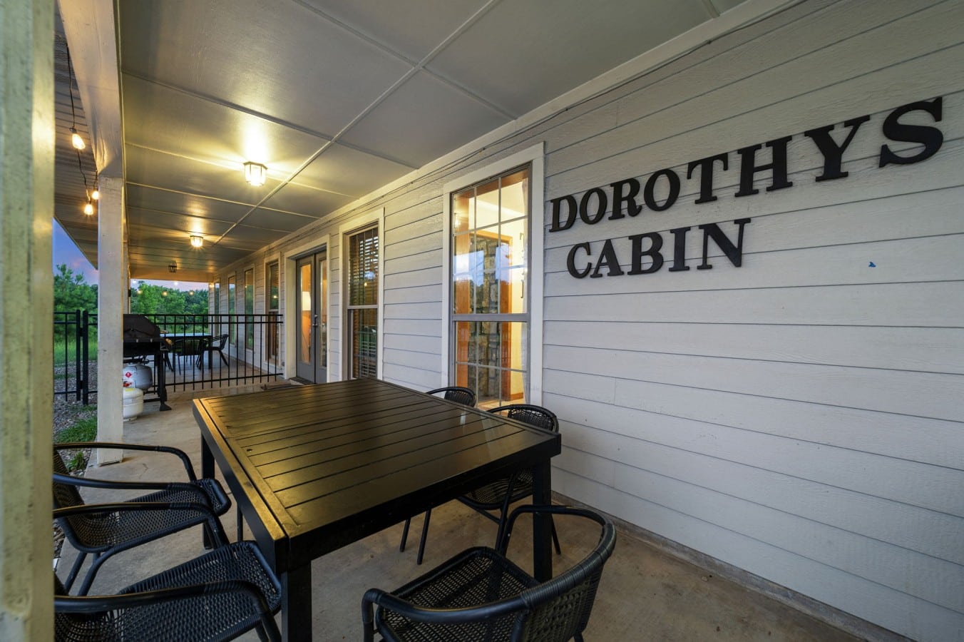 Covered patio seating and Dorothy's Cabin sign by the pool area.