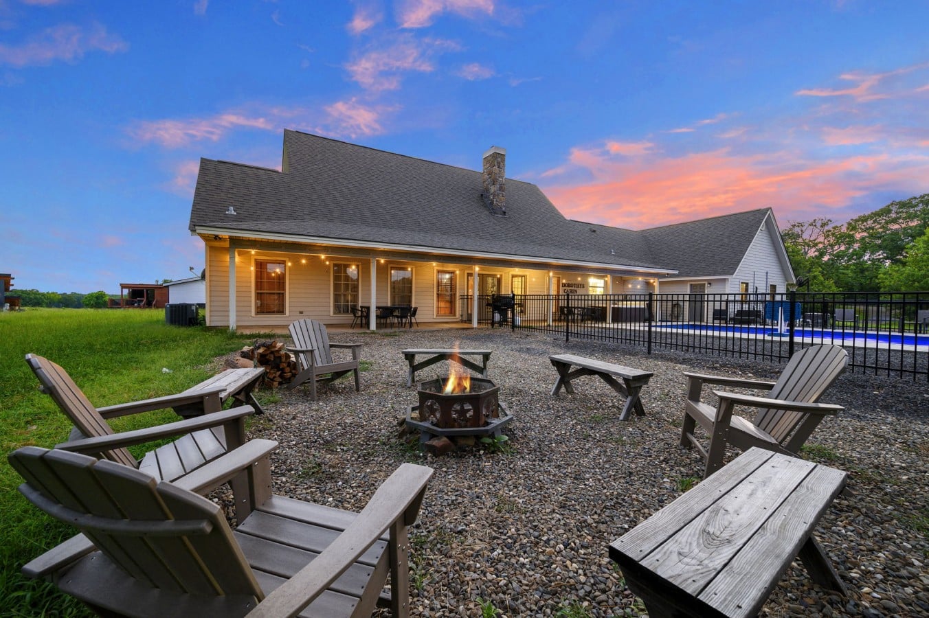 Fire pit seating near the pool and covered patio.