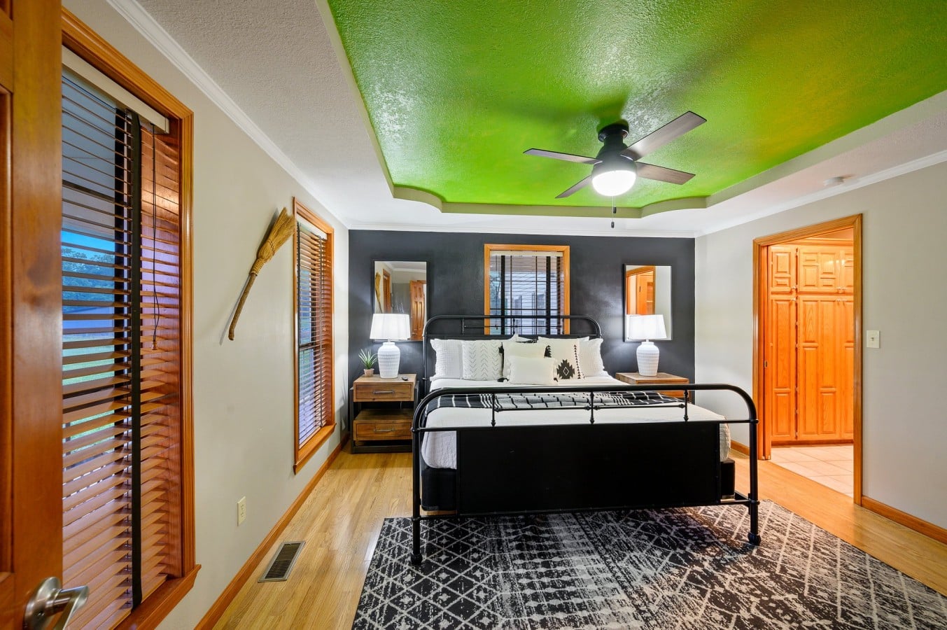 Green-ceiling bedroom with king bed and bold accent color.