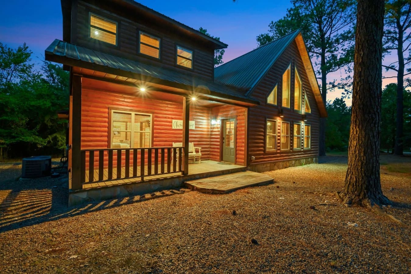This log cabin lit up at dusk with those glowing windows and the forest wrapped around it feels like stepping straight into your own private retreat in the woods.