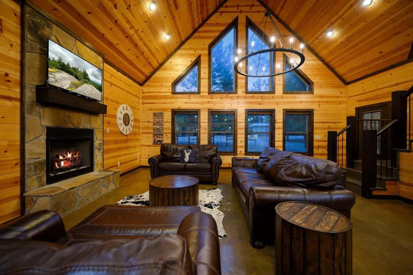 The fireplace keeps things warm while those four big windows frame the forest outside, and you've got enough leather seating to spread out and actually relax without feeling cramped.
