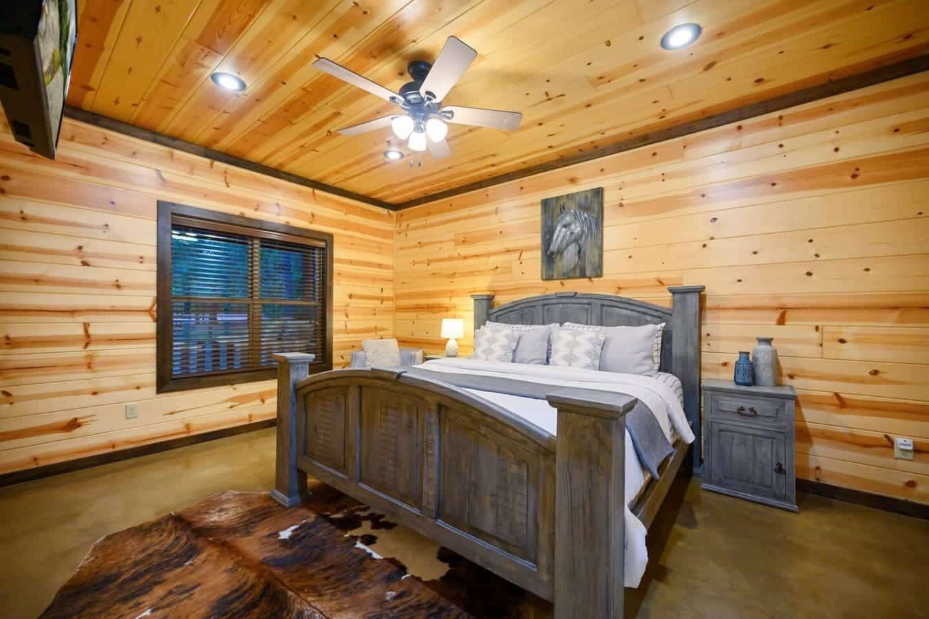 The wood-wrapped walls and vaulted ceiling give this bedroom that perfect cozy-cabin-lodge feel, and you've got a solid wood bed with rustic nightstands that actually makes you want to turn in early just to enjoy the space.