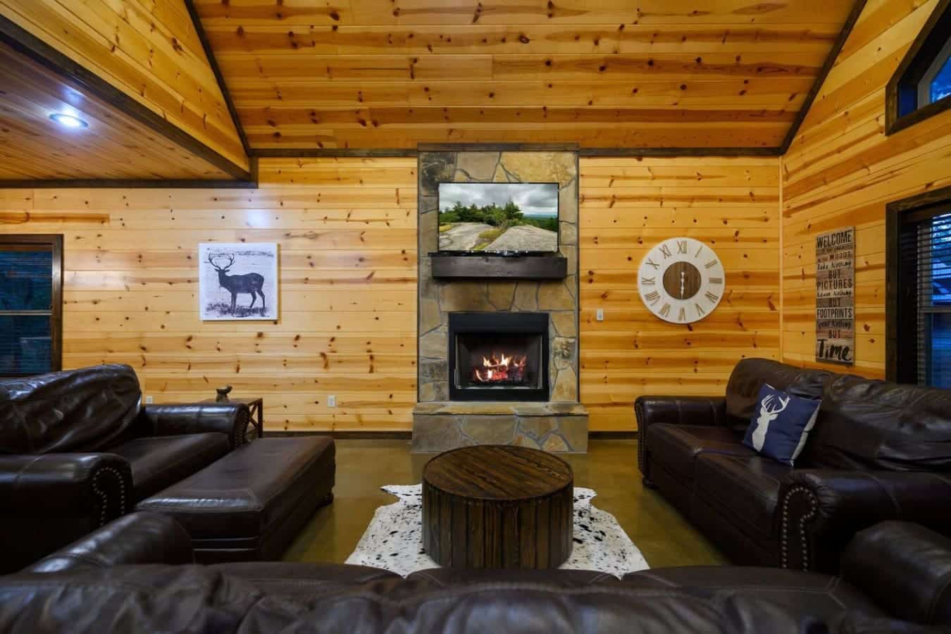 Sink into those leather chairs, get the fire crackling, and watch the flat-screen above the mantel while the whole room wraps you in warm wood and that cozy cabin feeling.