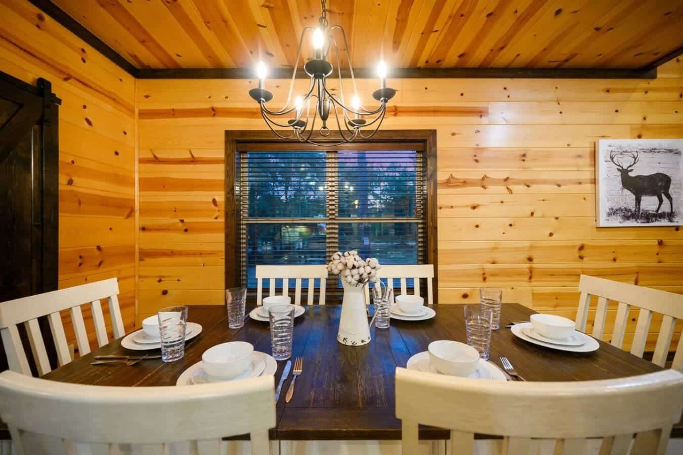Sit down at this round table with those big windows framing the dark water and forest beyond, and you've basically got the perfect setup for lingering dinners where nobody wants to leave.