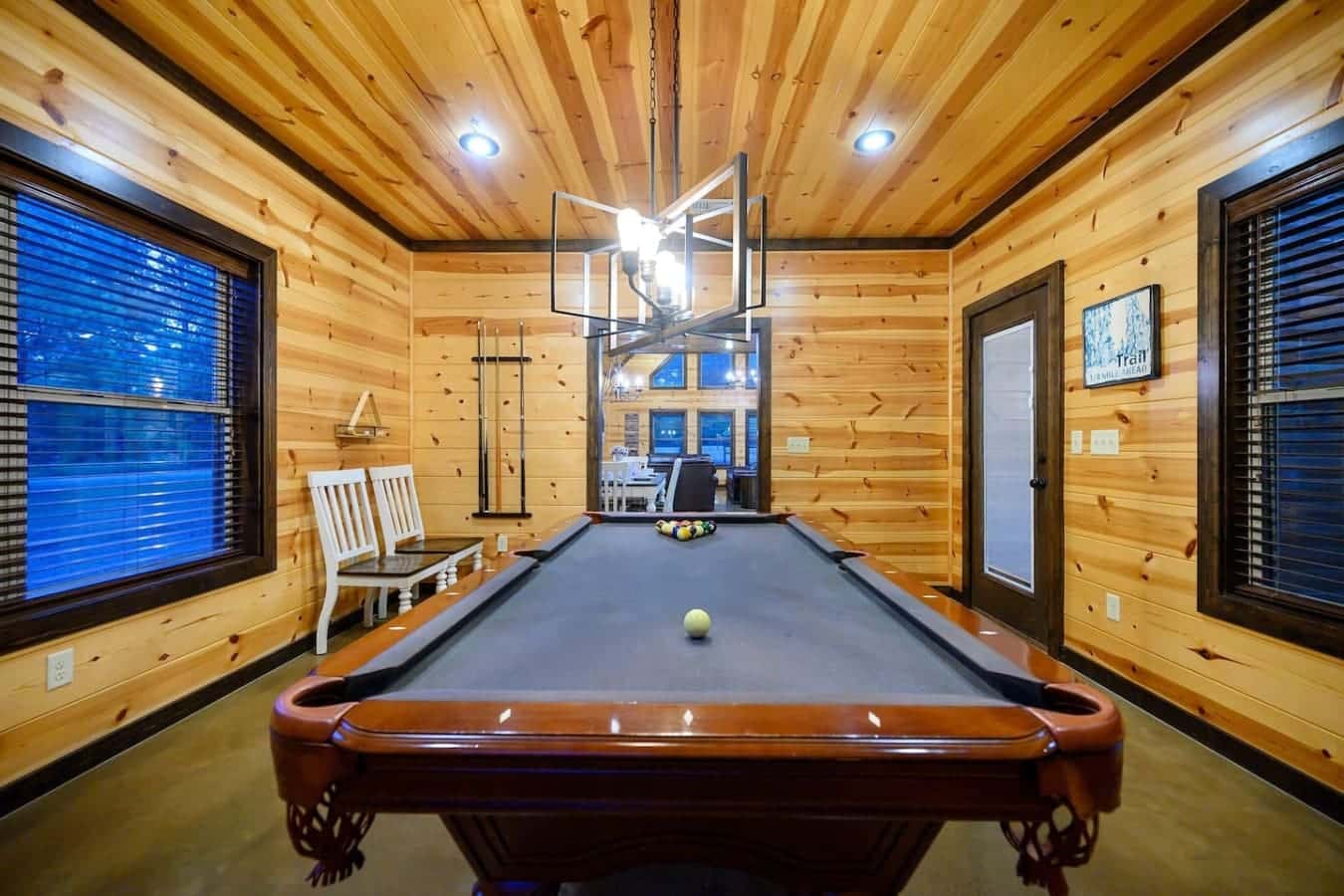 This game room is basically a log cabin dream come true—full-size pool table, swings hanging from the ceiling, and enough space to keep everyone entertained no matter what the weather's doing outside.