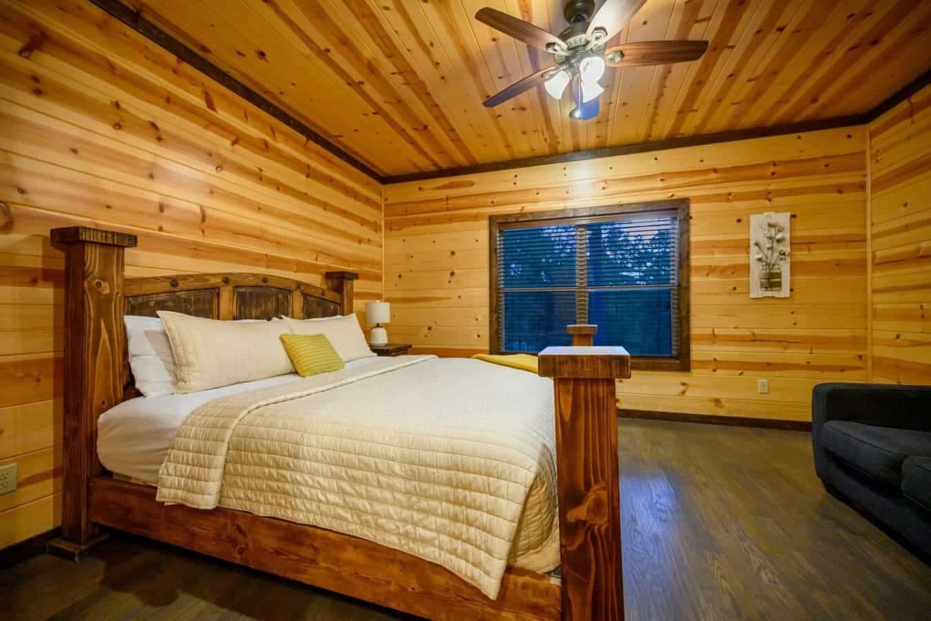 Wake up to those big blue-shuttered windows framing the forest, wood beams overhead, and a solid timber bed that makes you feel like you're sleeping in your own private lodge.