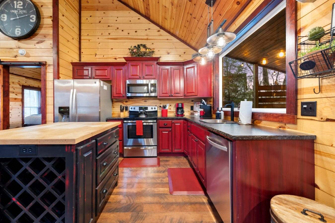 The kitchen features red cabinetry, a stainless steel refrigerator, and a modern microwave oven.