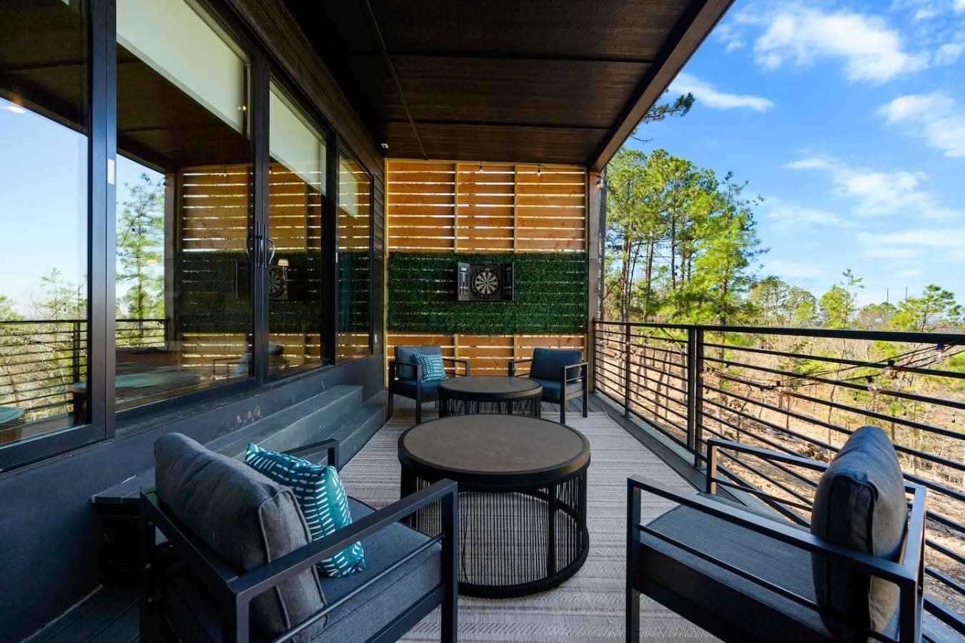 This elevated deck is basically the perfect spot to settle into those comfy chairs with a view, sip something warm, and watch the forest come alive while you're tucked under the overhang with all that natural light filtering through.