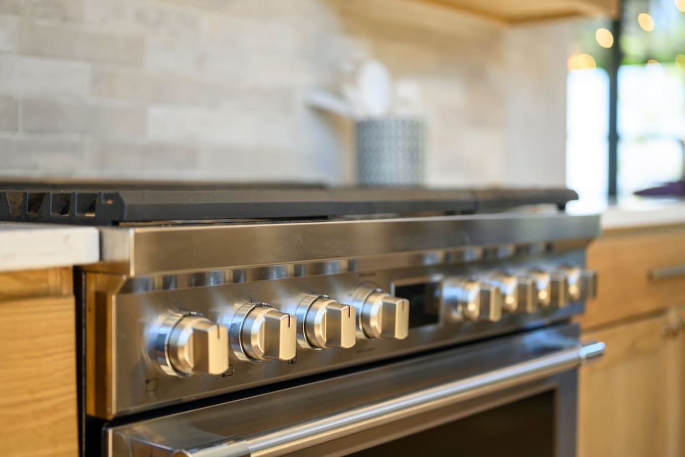 This sleek gas range with its polished stainless steel and golden knobs is basically the centerpiece of a chef's kitchen—built for serious cooking with style.