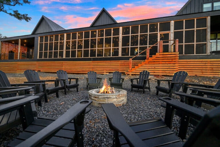 Picture yourself hanging out by the fire pit as the sun sets, surrounded by plenty of Adirondack chairs and that stunning modern barn backdrop.