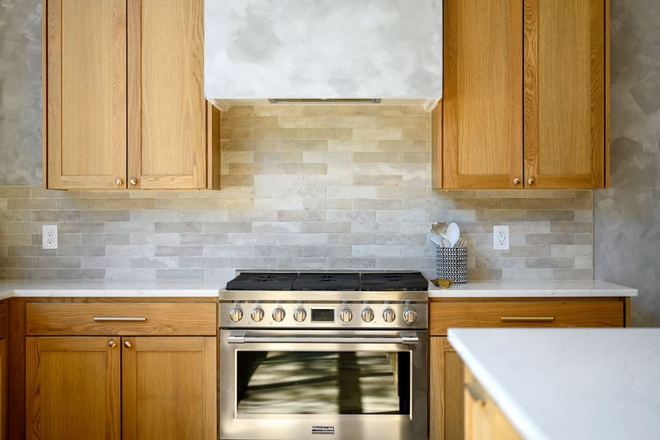 This kitchen is a total dream with those warm wood cabinets, sleek stainless steel range, and that beautiful neutral tile backsplash that somehow manages to feel both modern and cozy all at once.