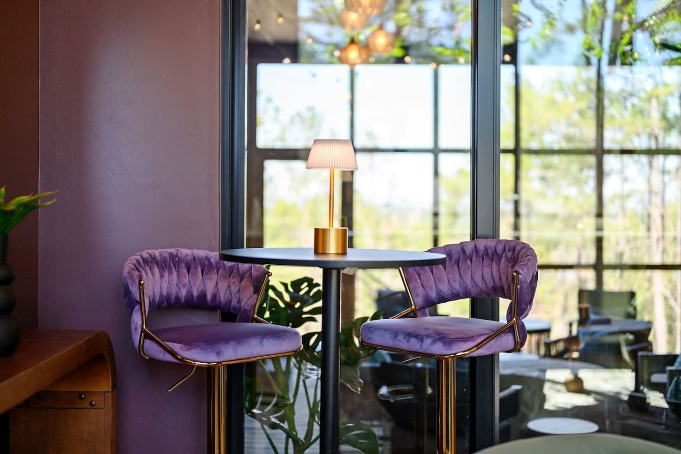 Settle into one of these plush purple velvet chairs by the window with that brass table lamp, and you've basically got the perfect little nook to watch the forest while you daydream the day away.